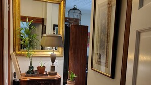 A hallway with a wooden cabinet, a mirror, a lamp, and a potted plant. - Enjoyable 1-bedroom apartmen
t with AC in vibrant Brooklyn (Brooklyn)