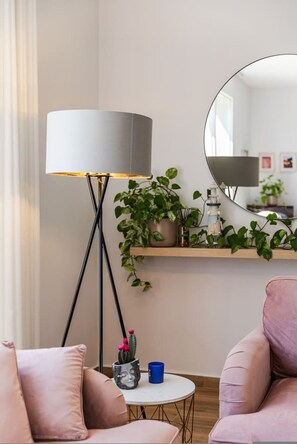 A modern living room with a floor lamp, a round mirror, a small round table, and a sofa. - Coastal Bloom Villa Garden BBQ (Ishëm)