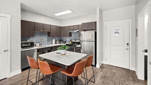 A modern kitchen with a central island, stainless steel appliances, and wooden cabinets. - Prime SLC - Airport - Convention - Hot tub (Salt Lake City)