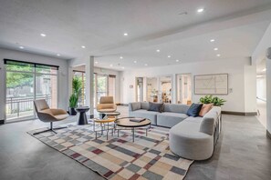 A modern lobby with a sofa, armchairs, a coffee table, and a patterned rug. - Delta - Airport - Hot Tub - Prime SLC (Salt Lake City)