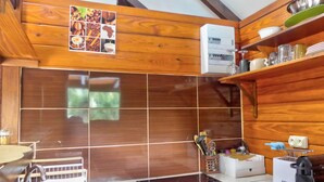 A kitchen with wooden cabinets, a tiled backsplash, a coffee machine, and a sink. - Cozy cottage "Cocotier" w/pool in the complex (Cul de Sac)