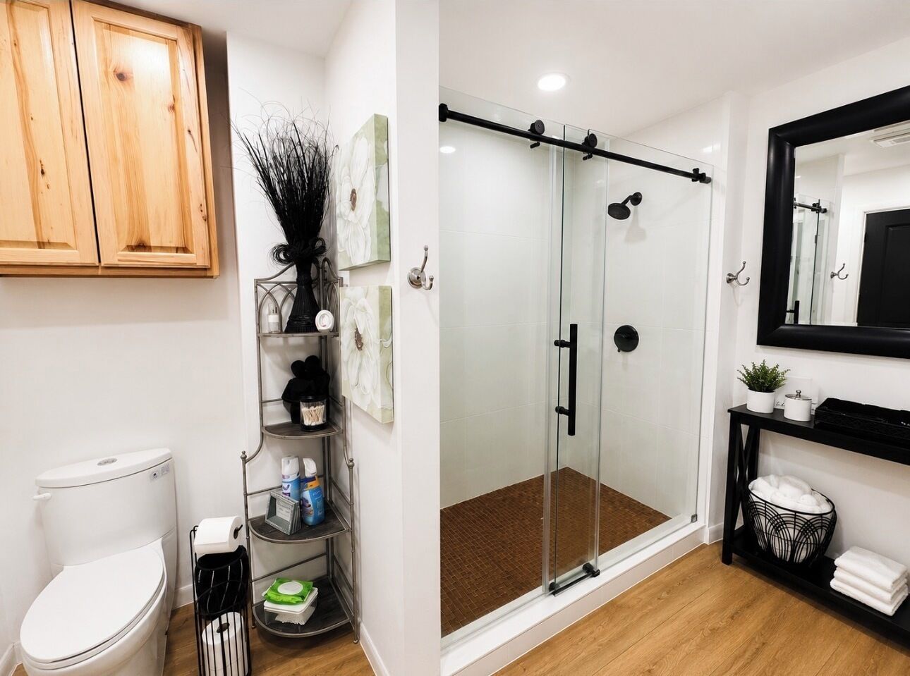 A modern bathroom with a toilet, shower, and storage shelves.