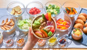 A variety of food items in bowls and small dishes, including fruits, vegetables, and nuts, arranged on a table. - A VILLAGE (Fujikawaguchiko)