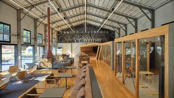 A spacious indoor area with a high ceiling, seating arrangements, and a fireplace.