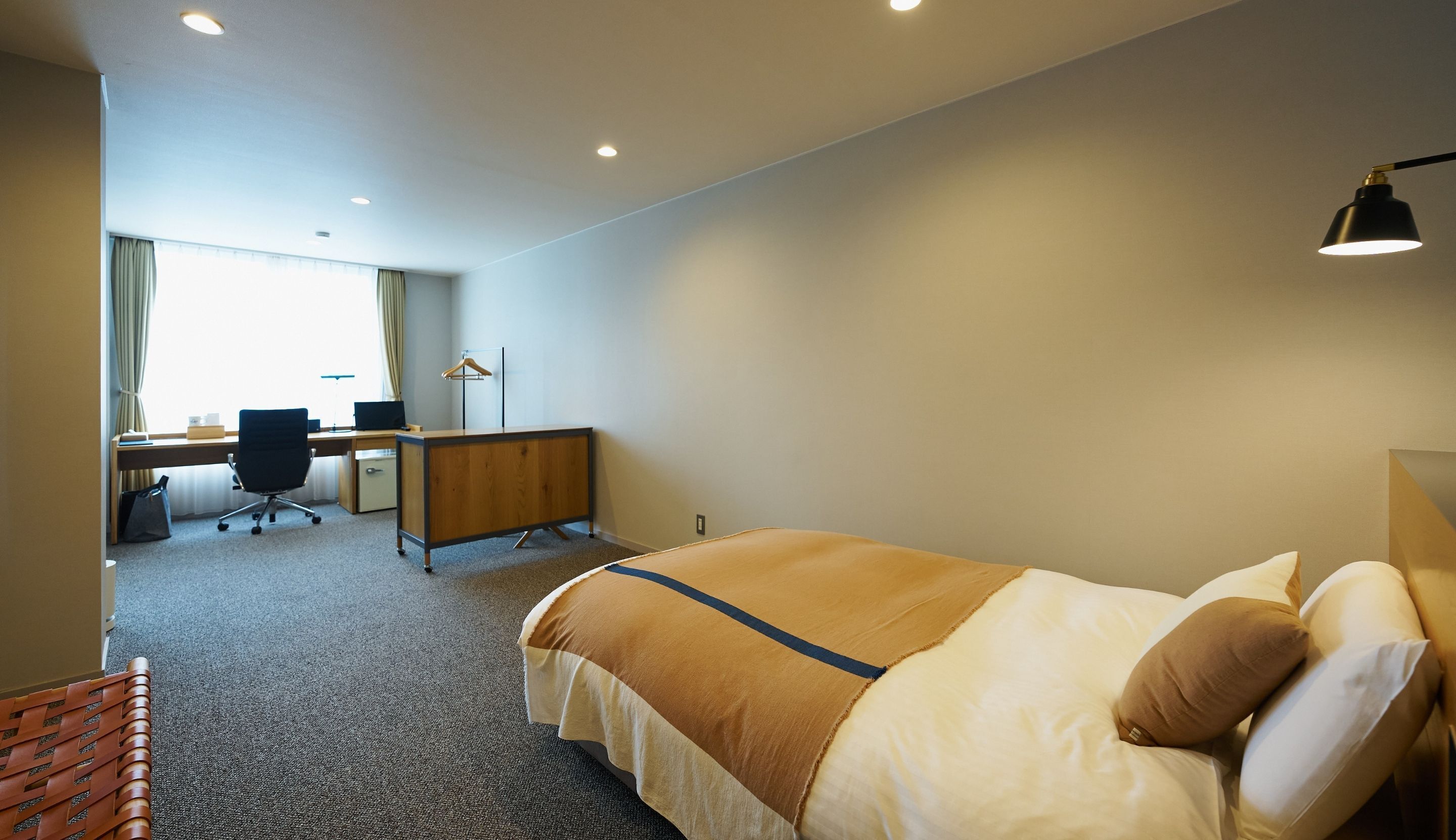Ein Hotelzimmer mit Bett, Schreibtisch und Stuhl.