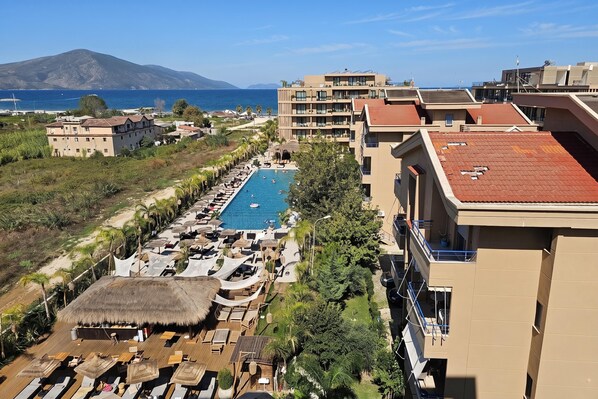 A resort with a swimming pool, lounge areas, and a view of the sea and mountains. - Pool Side Apartment, Vlore, Albania (Vlore)