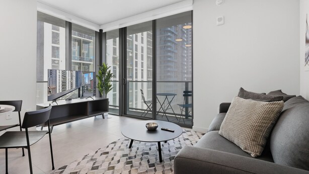 Un salon moderne comprenant un canapé, une table basse et un coin repas avec des chaises et une table.