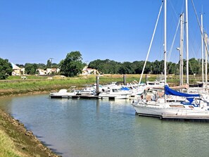 A marina with boats docked, calm water, and a grassy bank. - Single-storey house with wooded garden 50 metres from the port of Meschers/Gironde (Meschers-sur-Gironde)