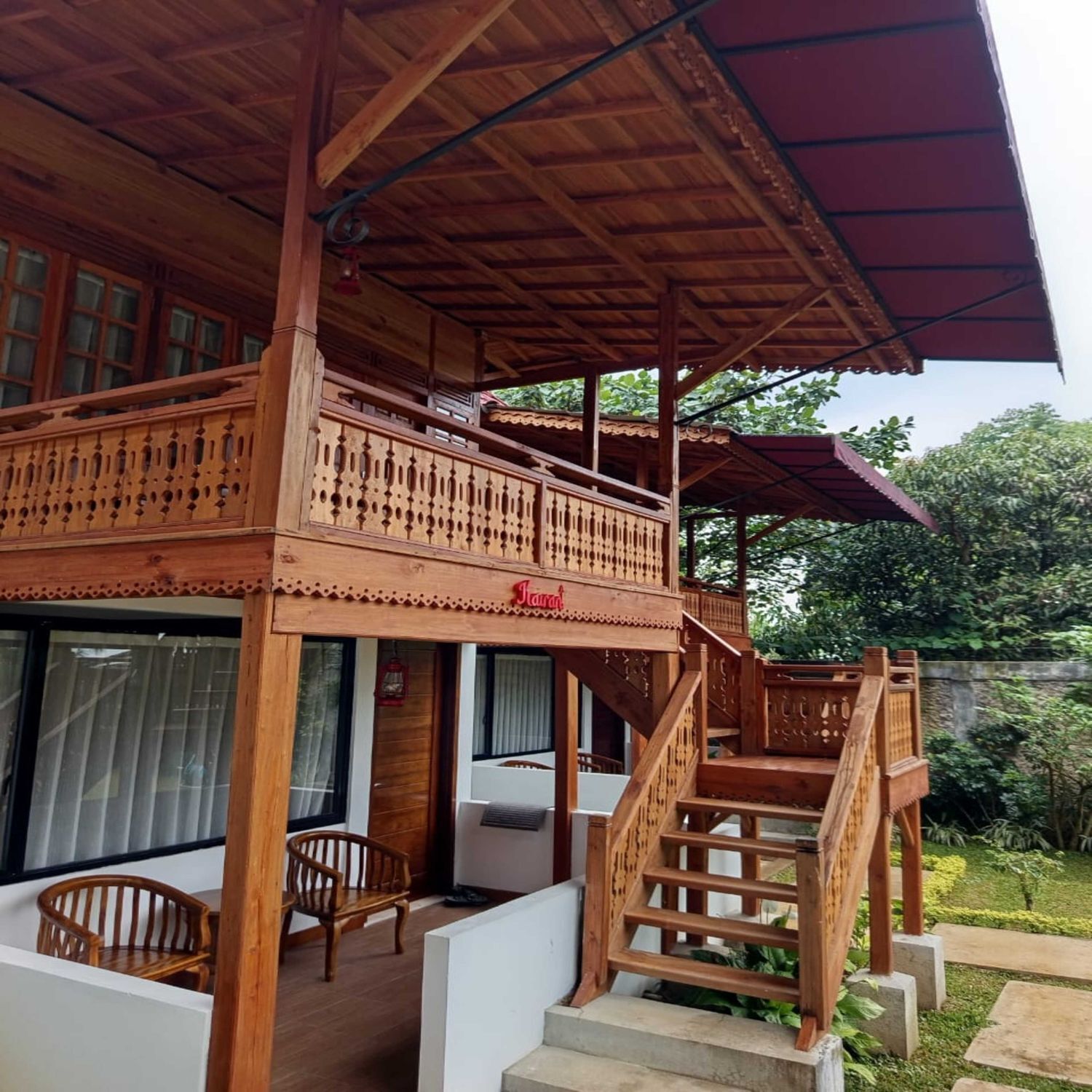 A wooden building with a balcony, a staircase, and a covered area.