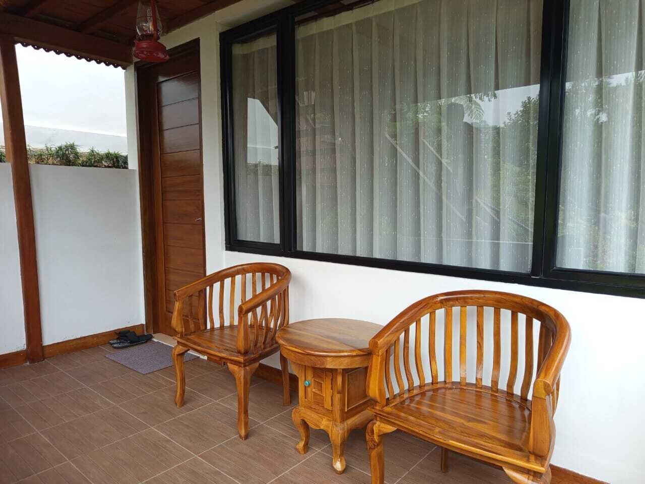 A wooden bench and table set on a tiled floor, with a window and a door in the background.