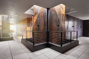 Interior moderno com escada, corrimãos de metal e soalho em azulejos.