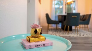 Ein Zimmer mit Essbereich, einem Tisch mit Stühlen und einem dekorativen Gegenstand auf dem Tisch.