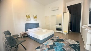 A bedroom with a bed, a chair, a nightstand, an air conditioning unit, and a door leading to another room. - Hotel O HNR INN (Kuala Terengganu)