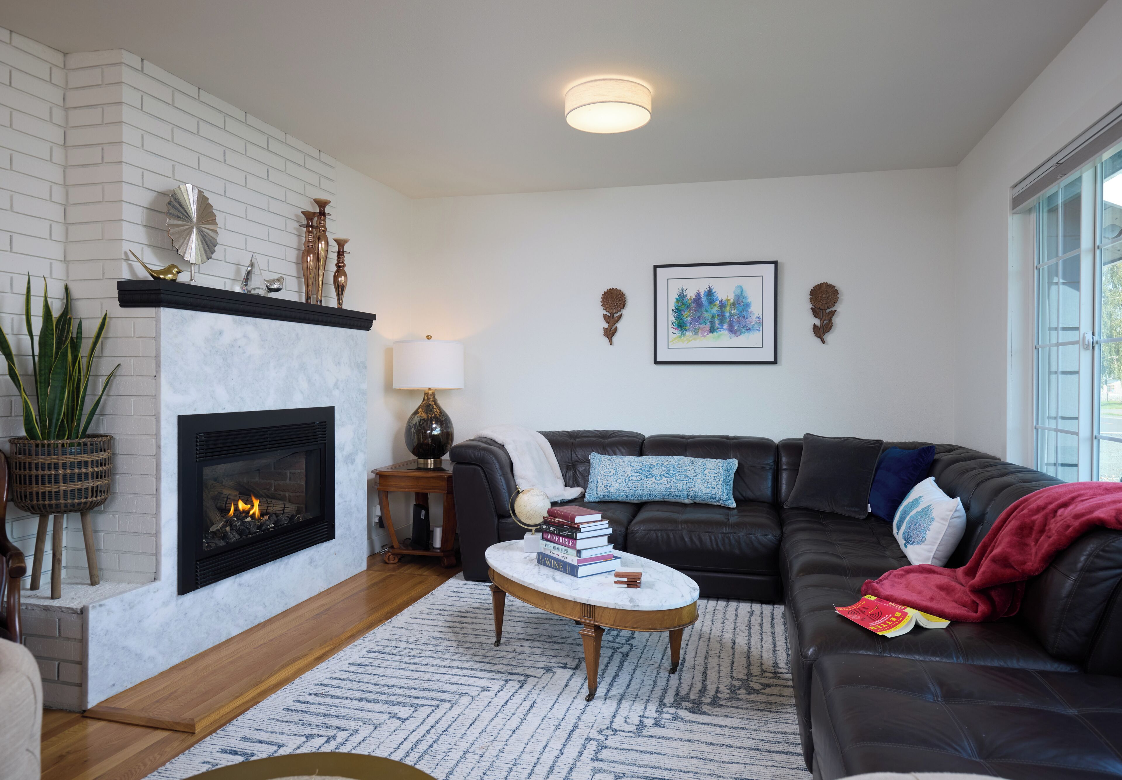A living room with a fireplace, a sofa, a coffee table, and a bookshelf.