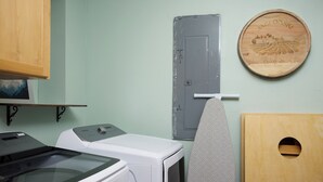 A laundry room with a washing machine, dryer, and a wooden plaque on the wall. - Sleep Inside Wine Country | 4BR, Fireplace (Milton-Freewater)