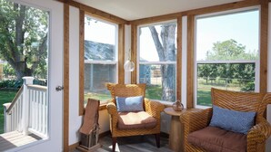 A sunroom with wicker furniture, large windows, and a view of the outdoors. - Sleep Inside Wine Country | 4BR, Fireplace (Milton-Freewater)