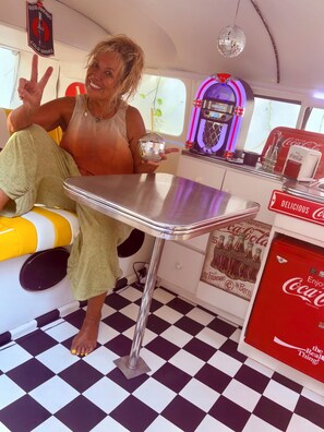 Ein Interieur im Retro-Stil mit Schachbrettmuster, einer Discokugel und Coca-Cola-Branding.
