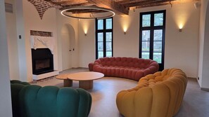 Un salon moderne avec une cheminée, une table basse ronde et des canapés.