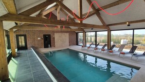 An indoor swimming pool with a view of the countryside, wooden beams, and sun loungers. - Gîte with 9 rooms for 24 people (BRAINE LE COMTE)