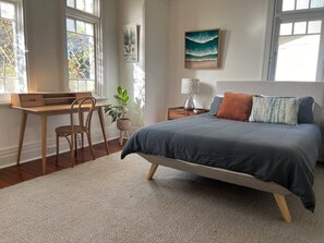 A bedroom with a bed, a desk, a chair, a plant, and artwork on the walls. - Art Deco Coastal Retreat, 250m to Coogee Beach (Coogee)