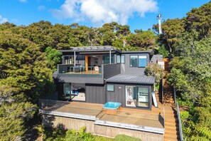 Uma casa moderna de dois andares com varanda, hidromassagem e deck.