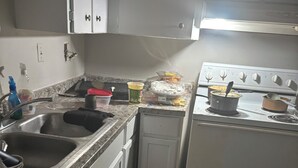 A kitchen with a sink, stove, and cabinets.