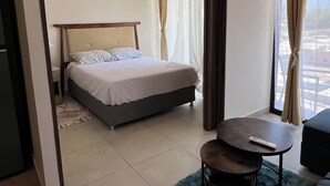 Une chambre d’hôtel avec un lit, une petite table, un canapé et une vue sur l’extérieur.