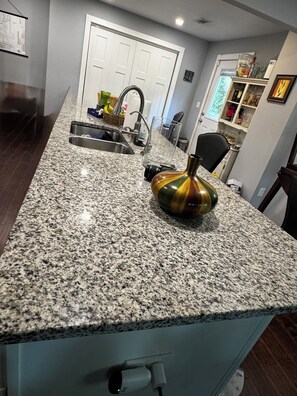 A kitchen with granite countertops, a sink, a vase, and a door in the background. - World Cup/Concert/Convention ready! Located near everything Atlanta has to offer (Atlanta)