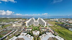A modern hotel with a central courtyard, multiple floors, and a view of the surrounding city and coastline. - 3rd Coast Getaways - Sunchase IV 910 (South Padre Island)