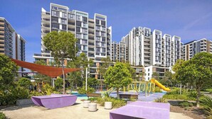 A residential complex with modern buildings, a playground, and landscaped areas. - Eastgardens 2BR/2BA | 2 Parking + Shops (Eastgardens)
