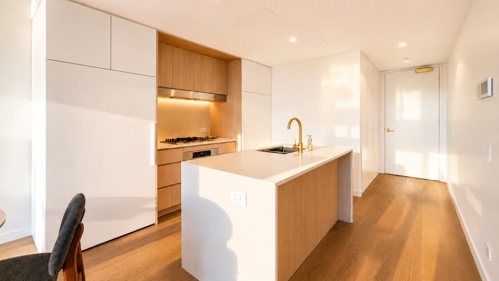 A modern kitchen with a central island, built-in cabinets, and a stove.