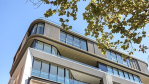 En modern byggnad med flera våningar, stora fönster och balkonger.