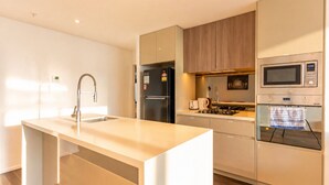 Una cocina moderna con una isla central, electrodomésticos integrados y un diseño minimalista.