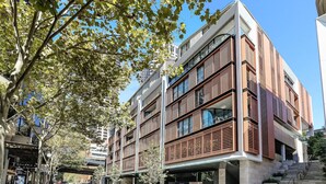 Ein mehrstöckiges Gebäude mit modernem architektonischen Design, mit Balkonen und großen Fenstern.
