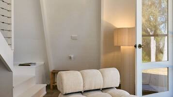 Ein modernes Interieur mit einer Couch, einem Holztisch und einer Treppe.