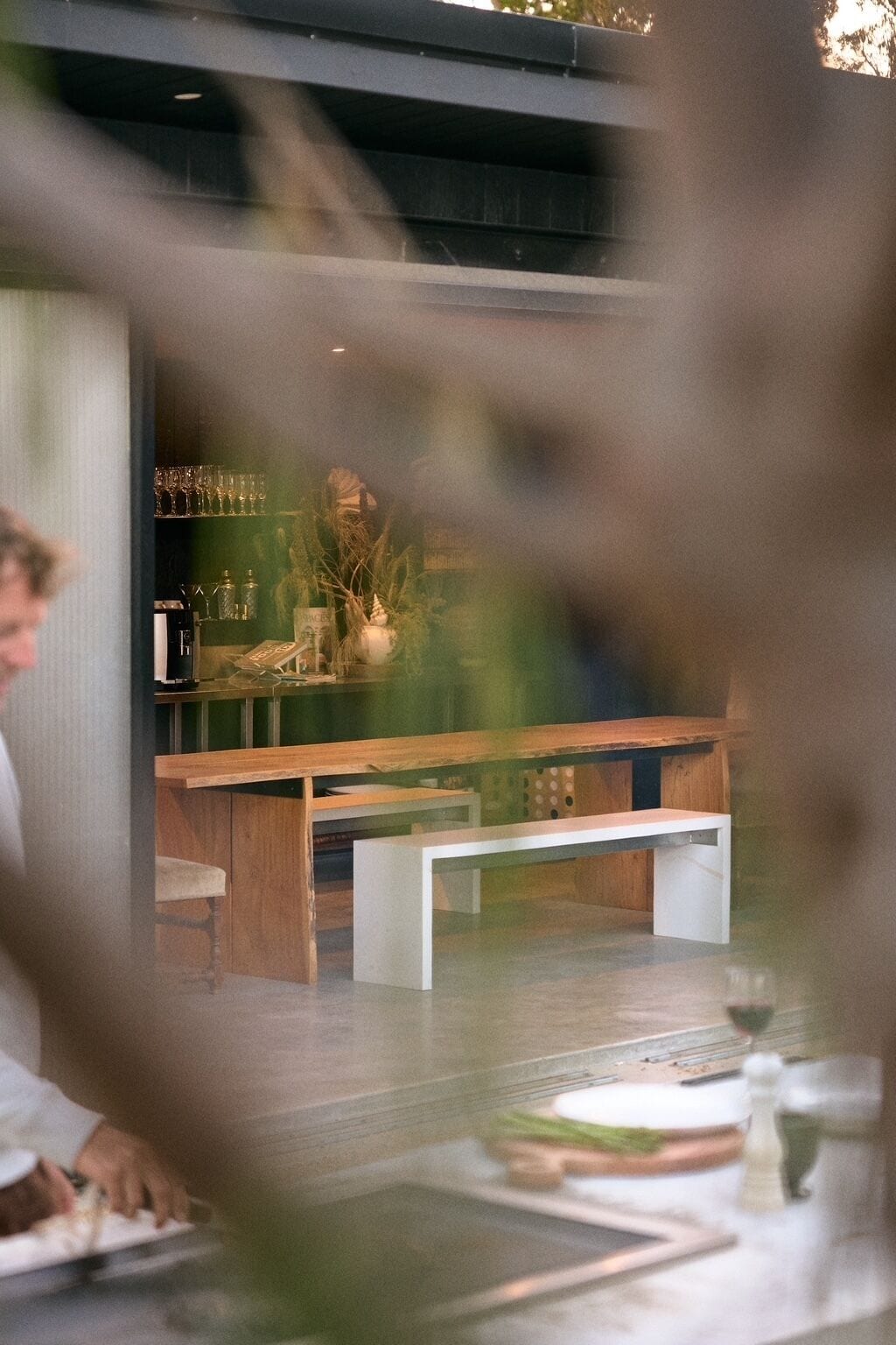 Interior de un restaurante con barra, asientos y una persona cenando.