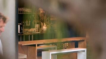 Interior de un restaurante con barra, asientos y una persona cenando.