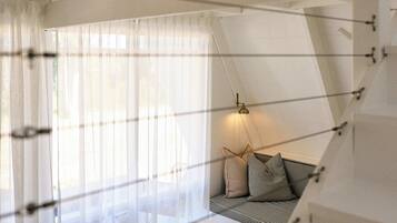 Una sala de estar moderna con un sofá, una mesa redonda de centro y una lámpara colgante.