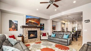 Una sala de estar con chimenea, sofá, comedor y cocina.