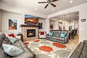 Ein Wohnzimmer mit Kamin, einer Couch, einem Essbereich und einer Küche.