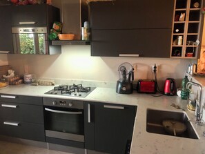 Eine Küche mit Gaskochfeld, Backofen und Spüle.