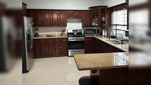 Una cocina con armarios de madera oscura, electrodomésticos de acero inoxidable y encimera de granito.