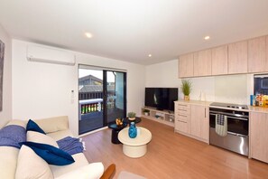 A modern apartment with a living room, kitchen, and balcony. - Central Christchurch Base for Your Stay (Christchurch)