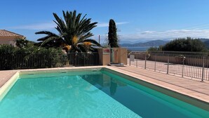 A rectangular swimming pool with clear water, surrounded by a tiled deck and a metal fence. - T2 sea and mountain view, large terrace ☀️ with swimming pool - 5 mn des Plages 🏖️ (L'Île-Rousse)