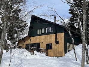 Eine Holzhütte mit großen Fenstern und einem Schornstein.