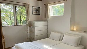 A bedroom with a bed, a wardrobe, a desk, and a window with curtains. - Walk to Tsugaike Ski Resort 200m. Floor heating, driveway heating, cosy & unique (Otari)