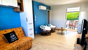 A modern living room with a sofa, two chairs, a small table, and a TV. - La Pause Jardaise near beaches (Jard-sur-Mer)