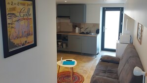Ein modernes Wohnzimmer mit einer Couch, einem kleinen Tisch und einem gerahmten Bild an der Wand.