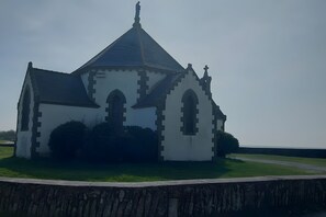 Església amb teulada a punta, finestres allargades i una creu al capdamunt.