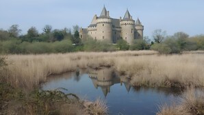 Eine schlösserartige Struktur mit mehreren Türmen und einem Burggraben.